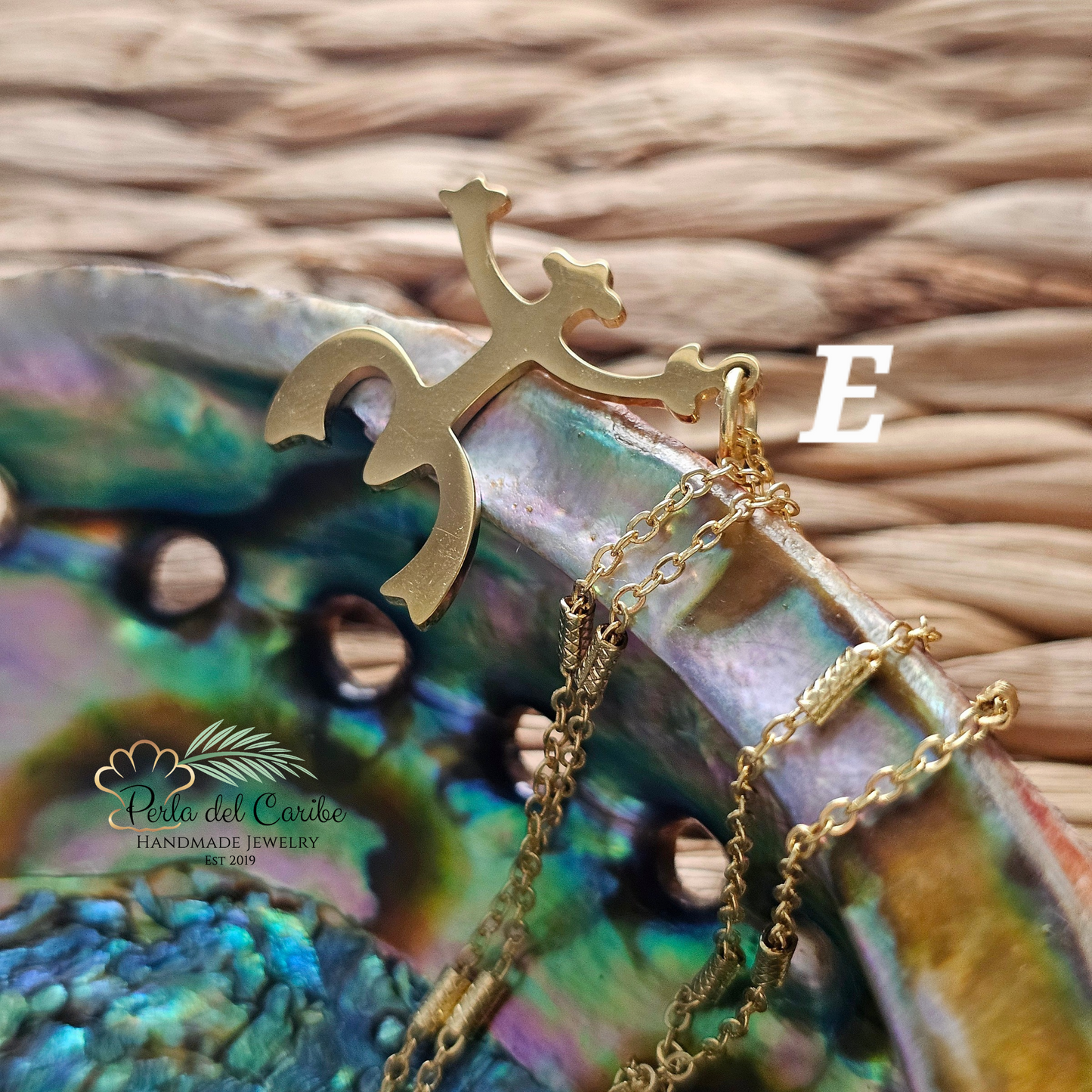 Gold necklace with a decorative clasp on a colorful shell background